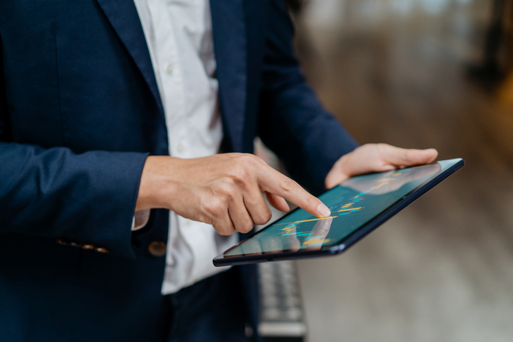 Image of businessman checking stock market chart on digital tablet. Tax-efficient investing